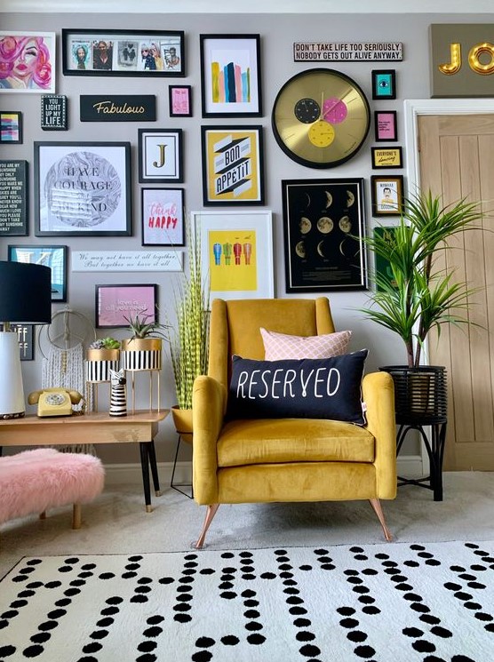 a stylish colorful gallery wall with matching black frames, colorful artworks and posters, a glam clock and bold prints