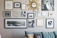 a stylish free form gallery wall with black, blonde wood and gold frames, with family photos and other prints and a mirror