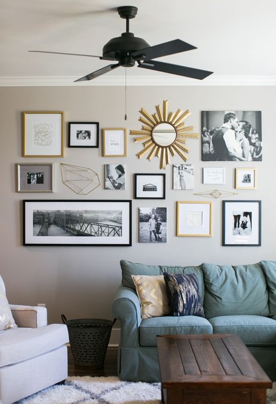 a stylish free form gallery wall with black, blonde wood and gold frames, with family photos and other prints and a mirror