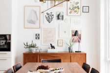 a stylish mid-century modern dining room with rich-stained and black furniture and a pastel free form gallery wall plus a chic chandelier