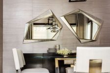a super elegant and refined dining room with taupe grasscloth wallpaper, a sleek black credenza, a lovely table and creamy and gold chairs, a geo chandelier
