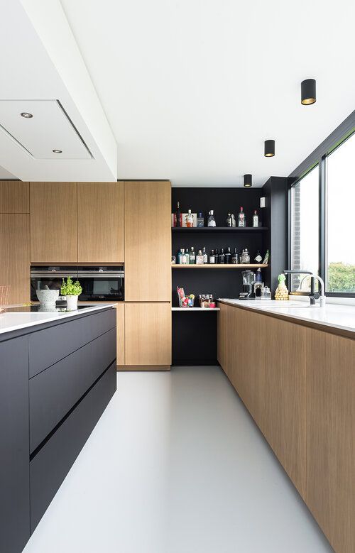 a two tone kitchen with sleek light stained cabinets, a black kitchen island and black open shelves in the corner