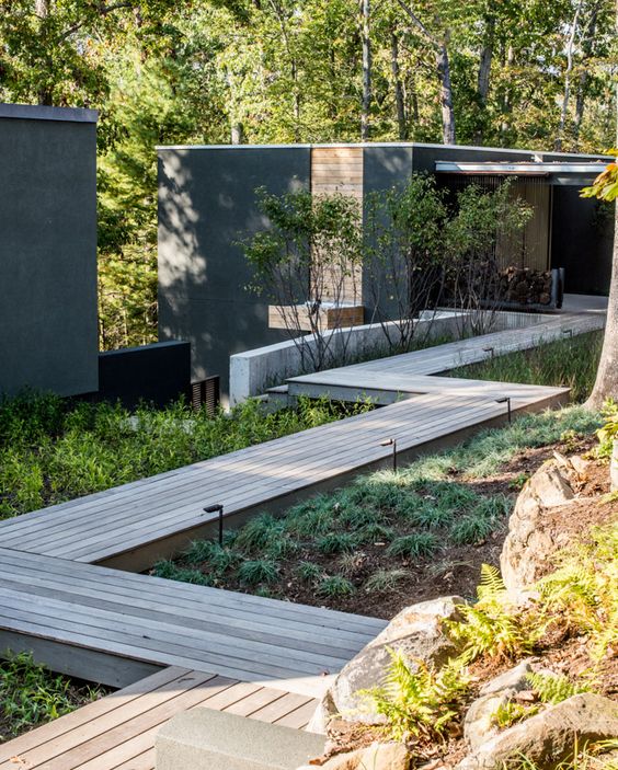 a weathered aged wooden raied walkway with greenery around and spotlights is a great solution for a contemporary space a weathered aged wooden raied walkway with greenery around and spotlights is a great solution for a contemporary space