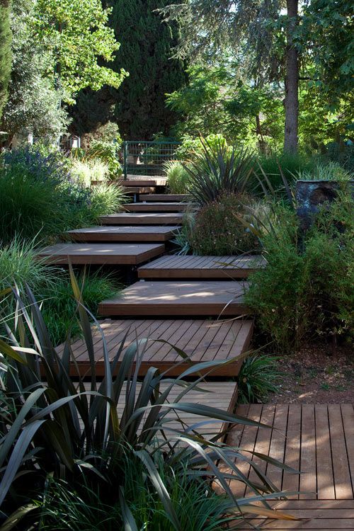 a wooden walkway placed of wooden pallet like tiles is a lovely idea for a modern or contemporary garden and adds a warm feel to the space a wooden walkway placed of wooden pallet-like tiles is a lovely idea for a modern or contemporary garden and adds a warm feel to the space