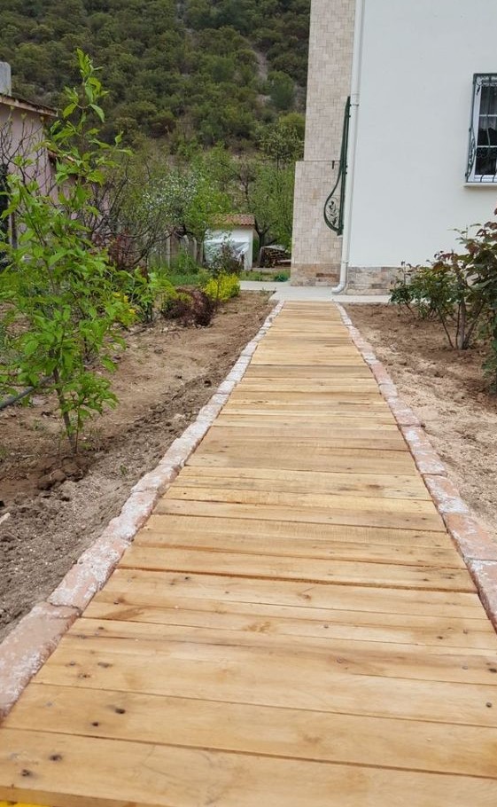 a wooden walkway with a stone edge is a cool rustic idea for many outdoor spaces and is easy to construct yourself