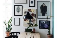 an eclectic dining room with a planked table, a pallet bench and black chairs plus a lovely free form gallery wall