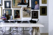 an eclectic dining space with a trestle table, ghost chairs, a black console table and a vintage gallery wall plus a boho rug