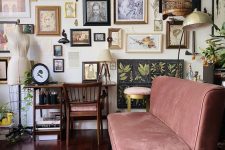 an eclectic living room gallery wall with various artwork, masks, mini sculptures and botanical posters is lovely