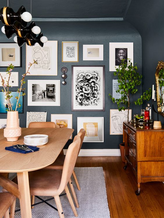 an exquisite graphite grey dining room with light stained furniture and a rich stained credenza, a free form gallery wall