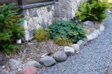 gravel and some stones match the stone cottage and look not too wild yet not too groomed