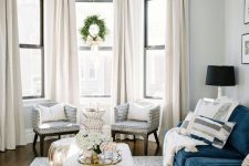 05 a bay window with several neutral curtains that add coziness and chic to the space and block out excessive sunshine