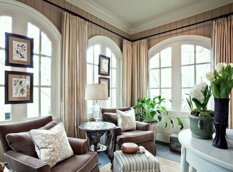 a cozy modern living room featuring a series of arched windows and neutral drapes on each of them is a lovely idea to rock