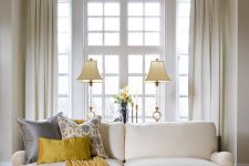 15 a large window with a half circle piece done with creamy drapes and the piece above stays uncovered – a stylish and cool solution