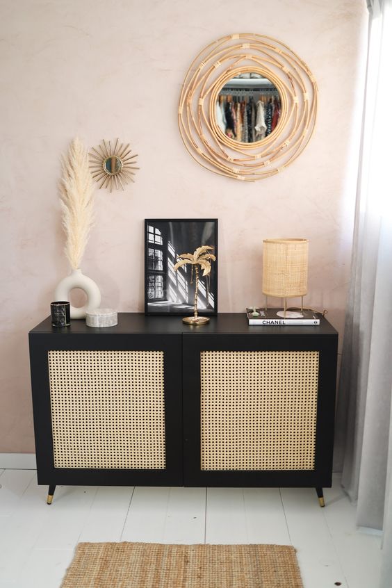 a black cabinet with black legs and cane webbing doors is a stylish and lovely idea for a modern bedroom, living room or entryway