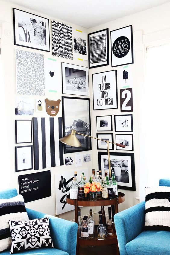 a bold corner gallery wall in black and white, with prints, artwork, photos and fun pieces is a cool idea for a modern space