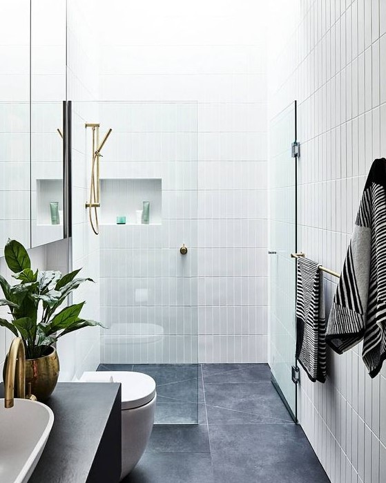a chic contemporary bathroom with grey tiles on the floor and white skinny tiles on the walls plus niches