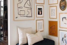 a chic gallery wall with gold and blonde wood frames and abstract art of various kinds