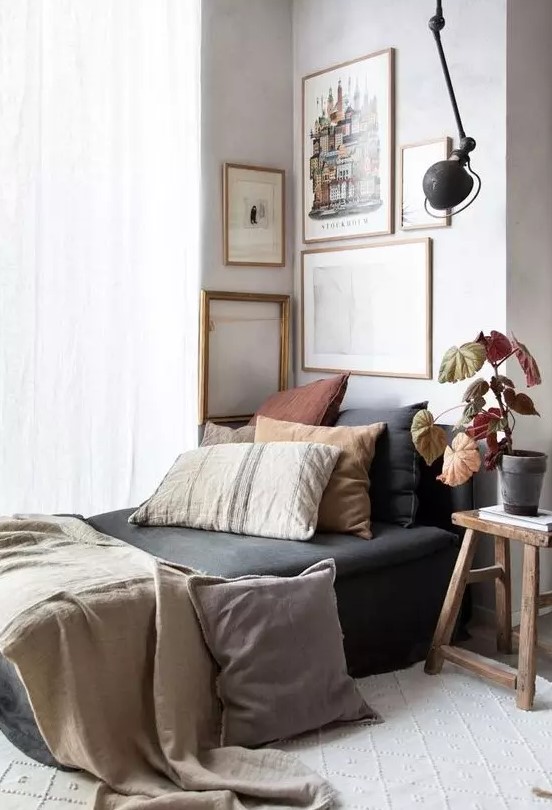 a chic gallery wall with mismatching frames but with the same gold finish and muted color or black and white art