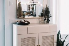 a chic white cabinet with cane webbing doors and gold knobs is a stylish idea for a classic or traditional space