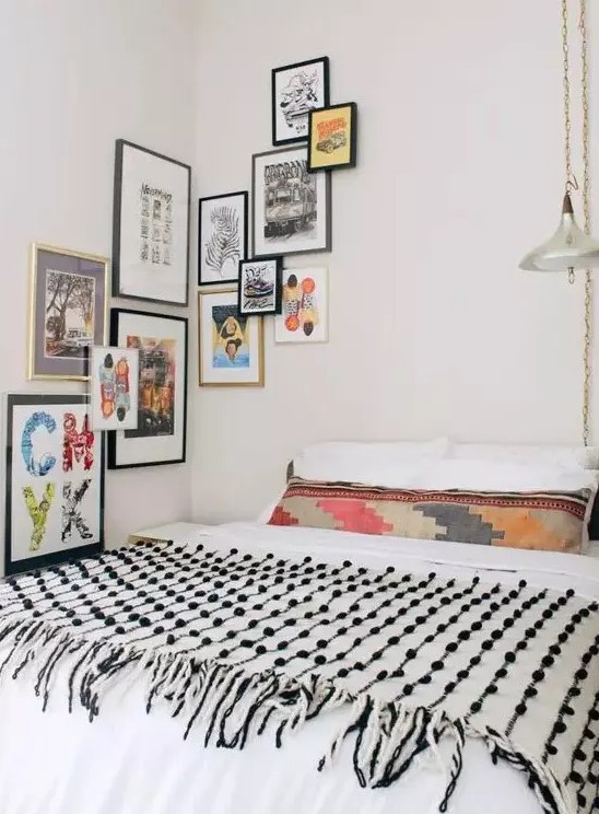 a colorful gallery wall with mismatching frames and colorful artworks covering two walls is a unique and bold idea