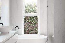 a contemporary to minimalist bathroom with a shower space enclosed in glass, a floating vanity, a tub and black fixtures