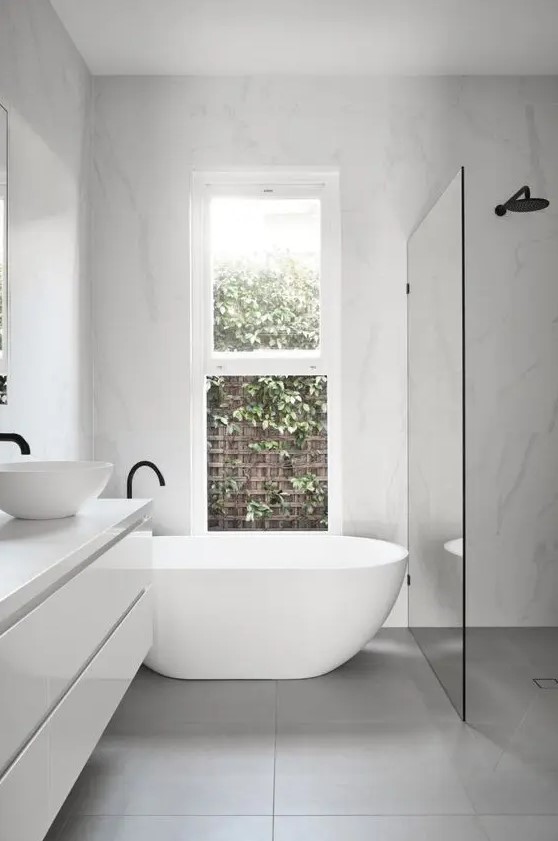 a contemporary to minimalist bathroom with a shower space enclosed in glass, a floating vanity, a tub and black fixtures