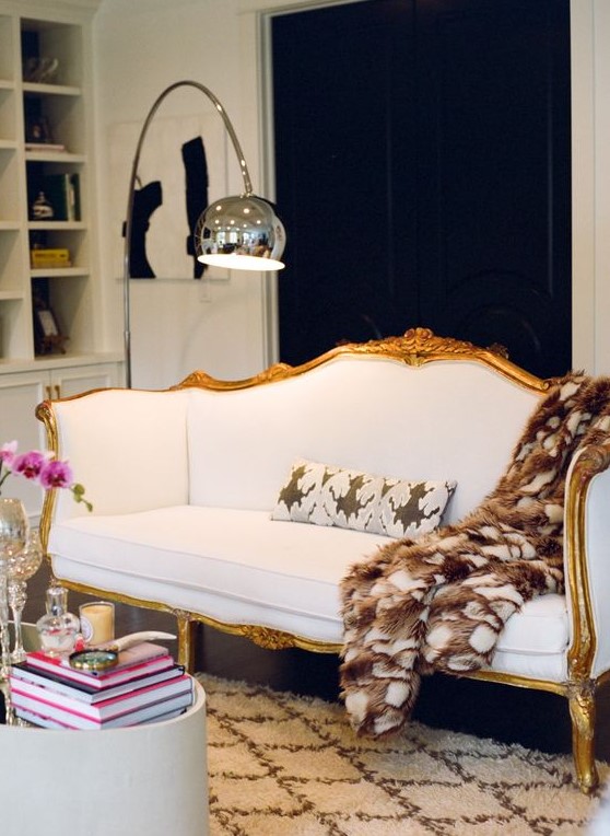 a contrasting contemporary space finished off with a beautiful vintage white sofa with gilded framing
