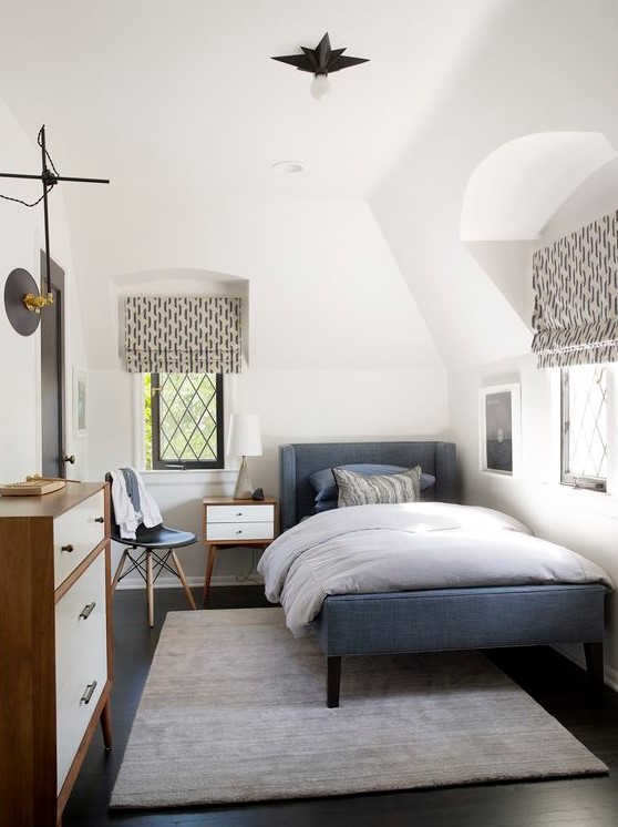 a cozy mid-century modern teen room with a blue upholstered bed, a dresser, printed textiles, a small nightstand and a chair