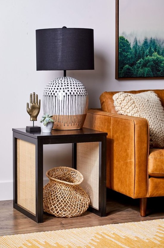 a dark side table with cane legs is a stylish and chic idea that brings texture and interest to the space