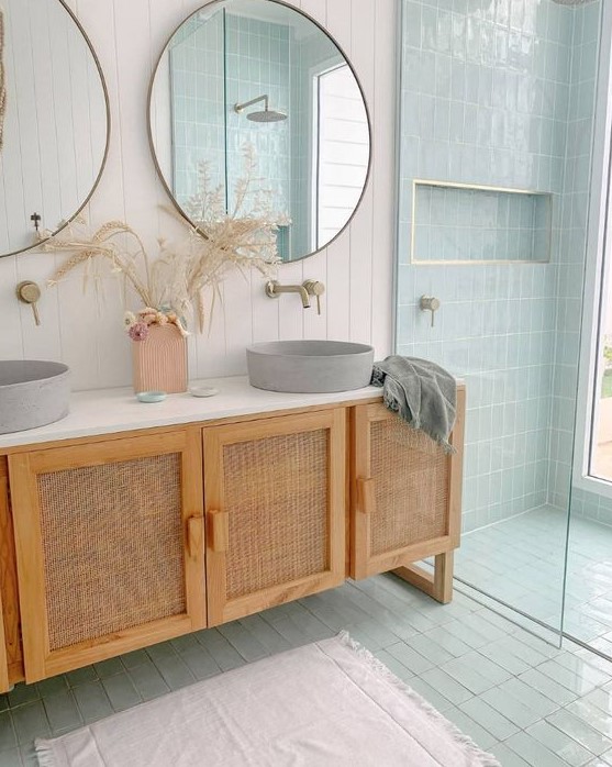 a double vanity with cane doors, round concrete sinks, round mirrors composes a very chic bathing space