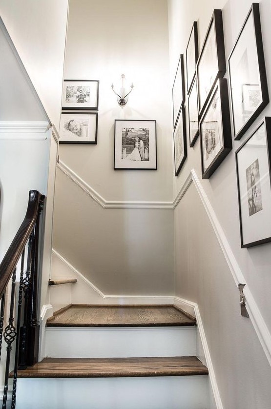 a free form gallery wall with matching black frames and black and white family pics is a lovely and artsy way to display the photos