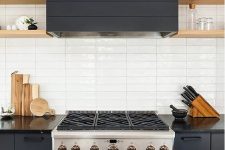a graphite grey kitchen with wooden shelves and a white stacked tile backsplash is very chic and bold