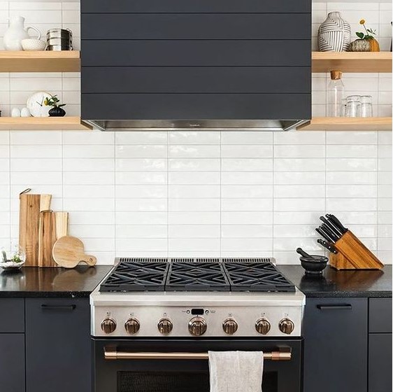 a graphite grey kitchen with wooden shelves and a white stacked tile backsplash is very chic and bold