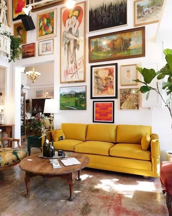 a large free form gallery wall with a bold color scheme and with vintage artworks will make the space more refined