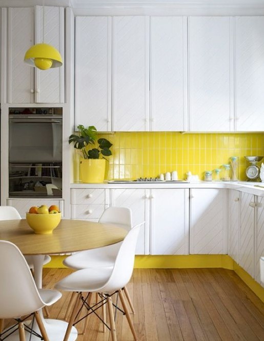 a lemon yellow accented kitchen with white cabinets and a yellow skinny tile backsplash that echoes bright accents and touches