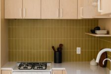 a light colored plywood kitchen with a mustard stacked tile backsplash and white fixtures for a fresh touch