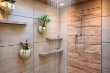 a minimalist bathroom with neutral tiles and wood, with a skylight over the shower space and potted plants on the wall