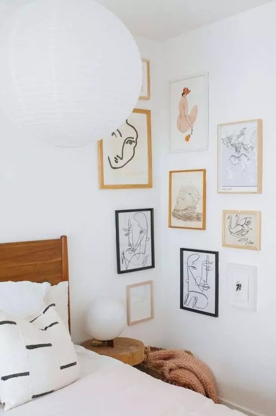 a neutral bedroom with a stained bed and neutral bedding, a creative corner free form gallery wall with catchy graphic art