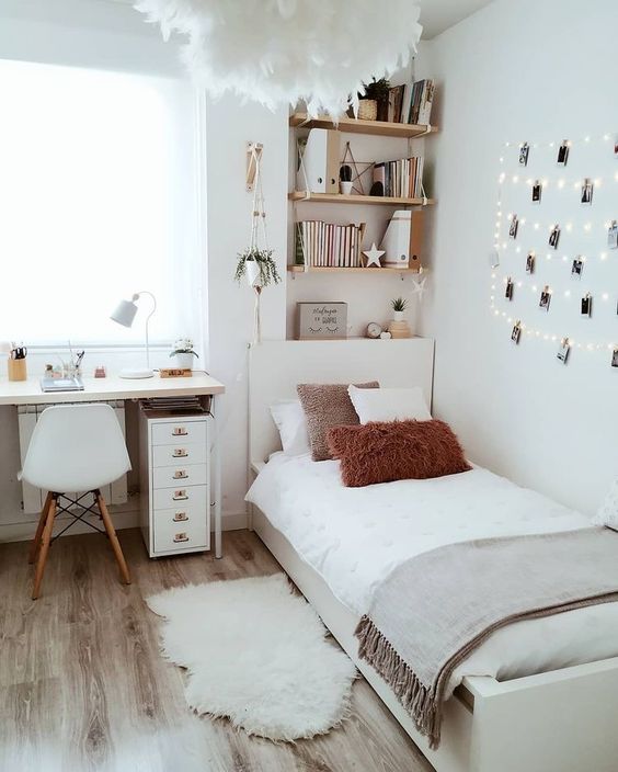 a serene Scandinavian teen bedroom with shelves, a desk, a bed, neutral textiles, a gallery wall with string lights and a fluffy lamp