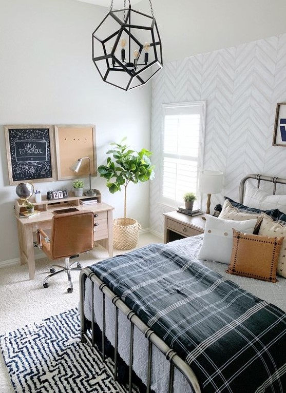 a stylish farmhouse teen room with a metal bed, lots of pillows, a small desk and a leather chair plus a faceted pendant lamp