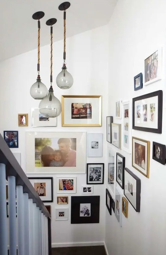 a stylish gallery wall with mismatching photos, frames of various sizes and colors is a very cool idea