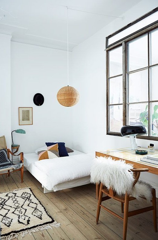 a teen Scandinavian room with a small bed, a desk and a chair, a rattan pendant lamp and a large window with no curtains