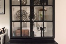a vintage black armoire with usual drawers and glass doors that allow you display beautiful things inside and make them stand out