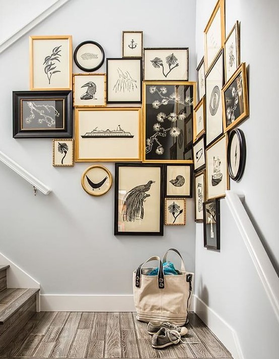 a vintage gallery wall taking the corner, with mismatching black and gold frames and pretty black and white vintage art