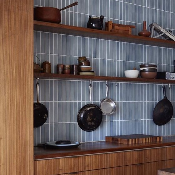 warm-toned wooden cabinets paired with a light blue skinny tile backsplash look contrasting and refreshed