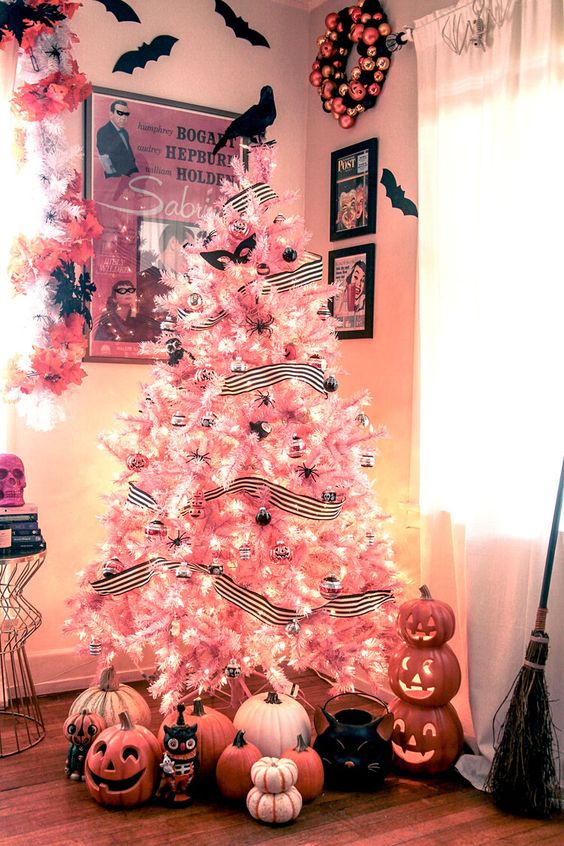 a pink Halloween tree decorated with striped garlands, black spiders, black and clear ornaments, lights and masks is a lovely idea