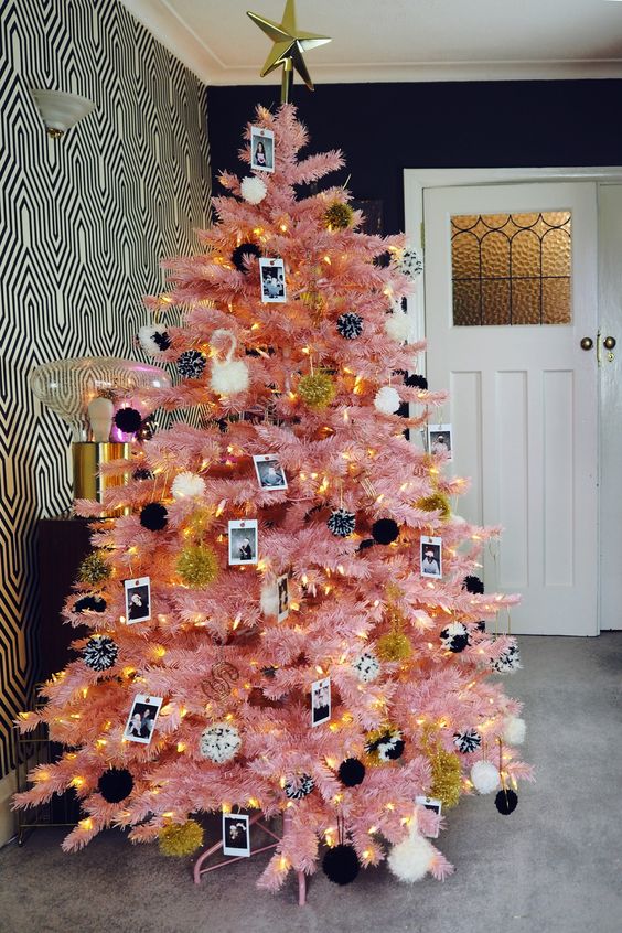 a pink Halloween tree decorated with black and white pompoms, lights and Polaroids in black and white is cool