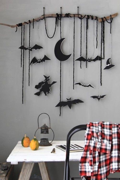 a wall hanging with black felt ornaments - half moons, witches, bats and just some twine, these ornaments can be used for Halloween tree decor