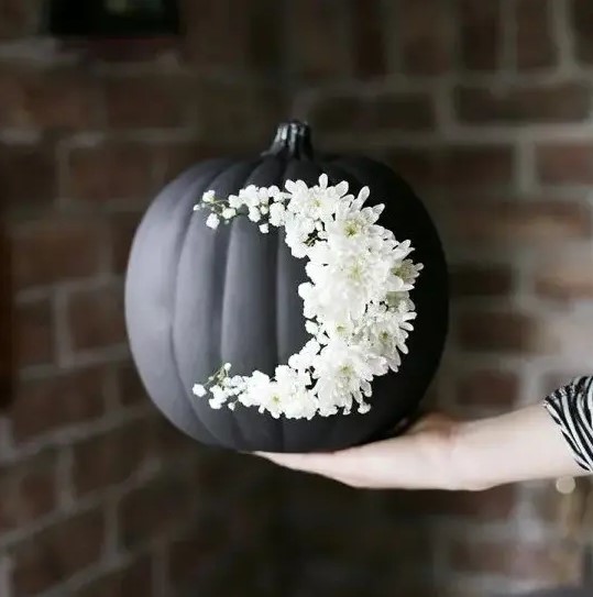 go for creative art decorating your matte black pumpkin with white blooms like that - this isn't a durable decoration but a very cool one