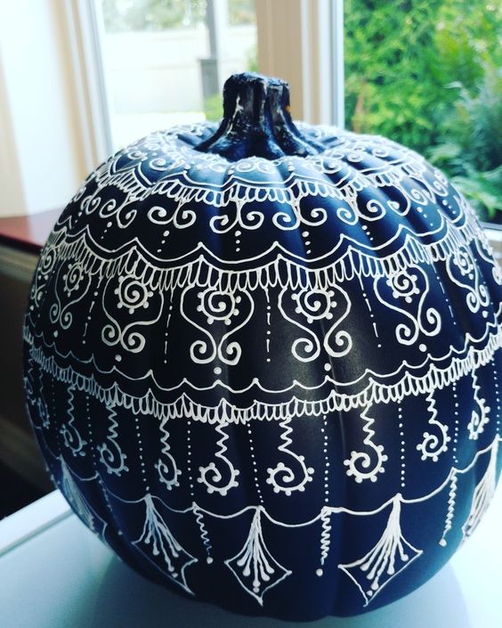 a black pumpkin decorated with a white sharpie with various patterns and designs is a lovely and bold idea for a boho Halloween